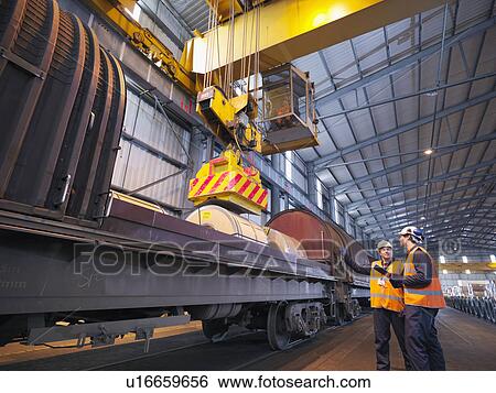 Stock Photograph - Port Workers Loading Cargo On To Train. Fotosearch