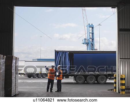 Stock Image - Port Workers Organizing Lorries. Fotosearch
