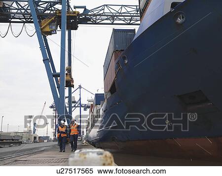 Stock Photography - Port Workers Walking Beside Ship. Fotosearch