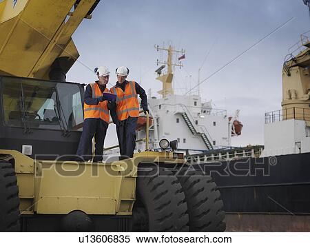 Stock Photography - Port Workers With Heavy Machinery. Fotosearch