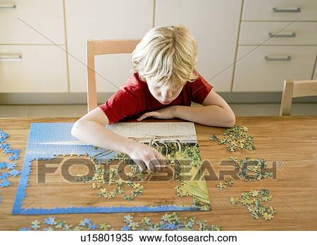 Portrait of a boy doing a puzzle View Large Photo Image Stock Photography - Portrait of a boy doing a puzzle. Fotosearch