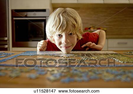 Stock Photo - Portrait of a boy with a puzzle. Fotosearch