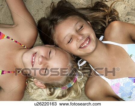 Stock Image - Portrait of girls on a beach. Fotosearch