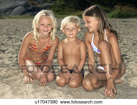Stock Image - Portrait of siblings on a beach. Fotosearch