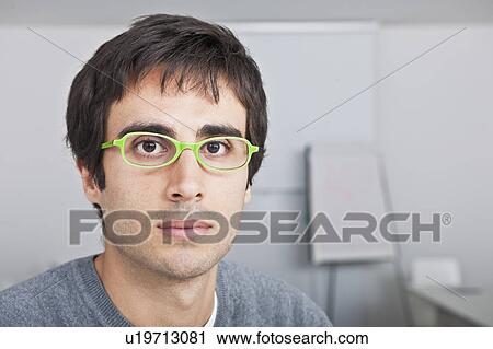 Stock Image - portrait of young man with green glasses. Fotosearch
