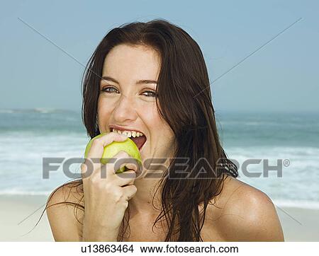 Portrait of young women eating an apple View Large Photo Image Picture - Portrait of young women eating an apple. Fotosearch