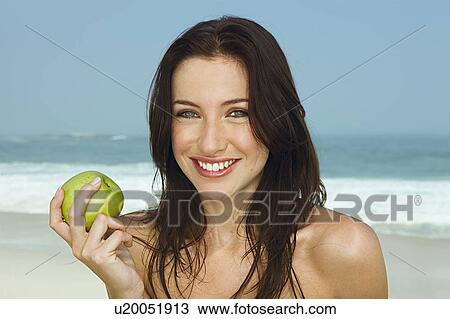 Portrait of young women eating an apple View Large Photo Image Stock Image - Portrait of young women eating an apple. Fotosearch