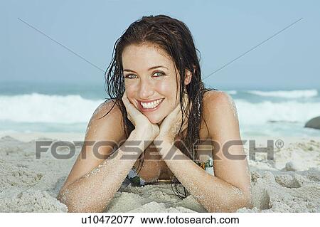 Portrait of young women lying on a beach View Large Photo Image Stock Photo - Portrait of young women lying on a beach. Fotosearch