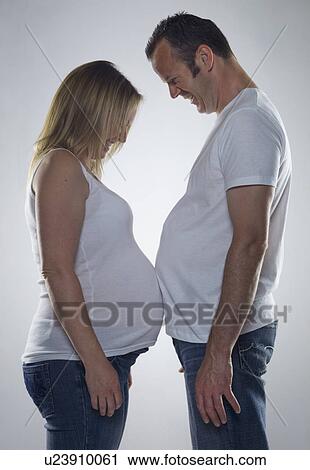 pregnant woman comparing bump with man View Large Photo Image Stock Image - pregnant woman comparing bump with man. Fotosearch