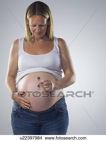 Picture - pregnant woman with key. Fotosearch