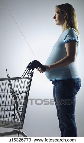 Stock Photo - pregnant woman with shopping trolley. Fotosearch