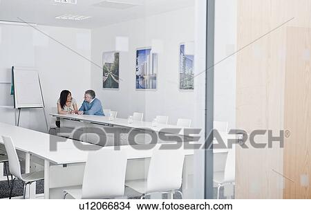 Picture - relaxed couple in meeting room. Fotosearch