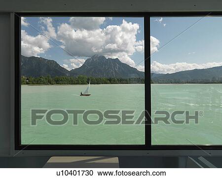 Stock Image - Sail boat crossing lake. Fotosearch