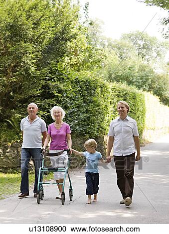 Stock Image - senior couple, father and son walking. Fotosearch