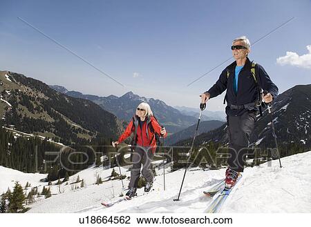Stock Image - senior couple on ski tour in mountains. Fotosearch