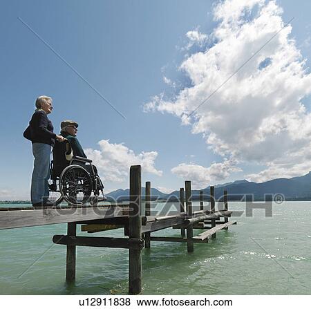 Senior couple relaxing by lake View Large Photo Image Stock Photo - Senior couple relaxing by lake. Fotosearch