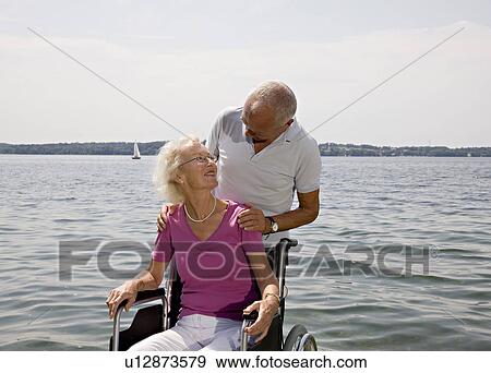 Stock Photo - senior man and woman in wheelchair. Fotosearch