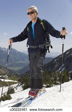 Stock Image - senior man on ski tour in mountains. Fotosearch