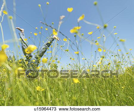 Stock Image - Senior woman cartwheeling through field. Fotosearch