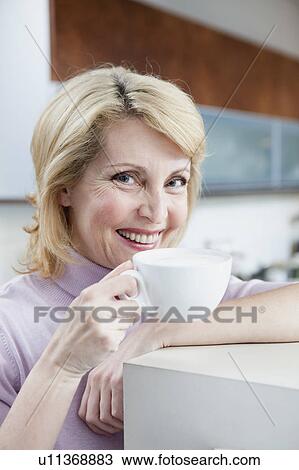 Stock Image - Senior Woman Drinking Cappuccino. Fotosearch