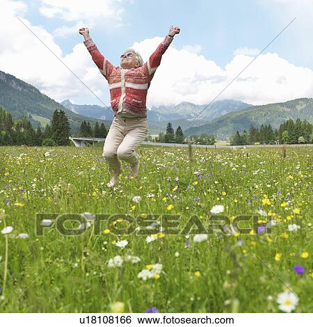 Senior woman leaping in field of flowers View Large Photo Image Stock Photograph - Senior woman leaping in field of flowers. Fotosearch