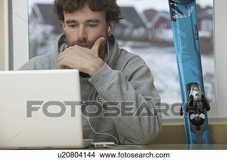 Picture - Skier checking his email.. Fotosearch