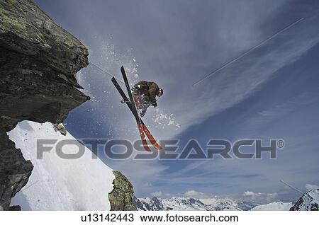 Stock Image - Skier jumping off a rock.. Fotosearch