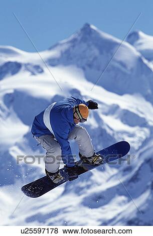 Stock Photo - Snowboarder jumping into the air. Fotosearch