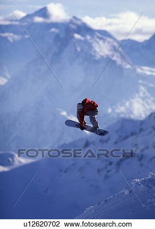 Snowboarder jumping with mountain view View Large Photo Image Stock Image - Snowboarder jumping with mountain view. Fotosearch