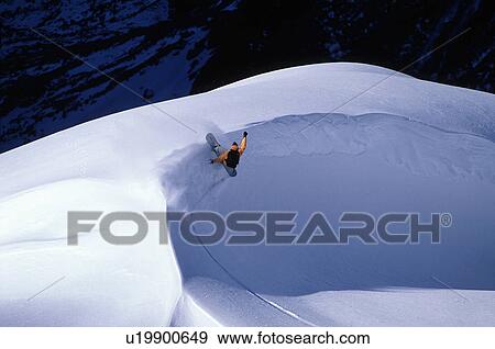 Stock Photo - Snowboarder turning around a snow bank. Fotosearch
