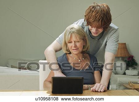 Son helping mother with laptop View Large Photo Image Stock Photo - Son helping mother with laptop. Fotosearch