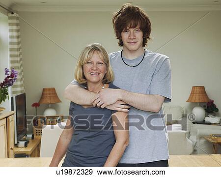 Son standing with arms around mother View Large Photo Image Stock Photo - Son standing with arms around mother. Fotosearch