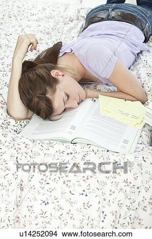 Picture - Student fallen asleep over her book. Fotosearch