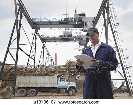 Stock Photo - Sugar Cane Worker At Processing Plant. Fotosearch
