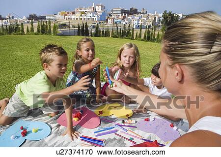 Stock Image - Teacher teaching students arts & crafts. Fotosearch