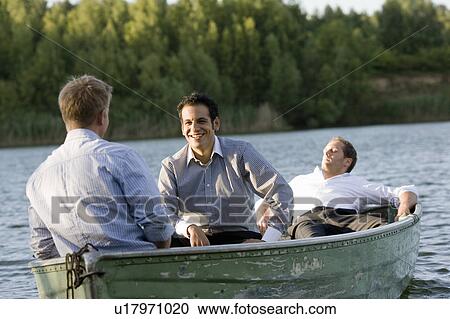 Stock Image - three businessmen relaxing in rowboat. Fotosearch