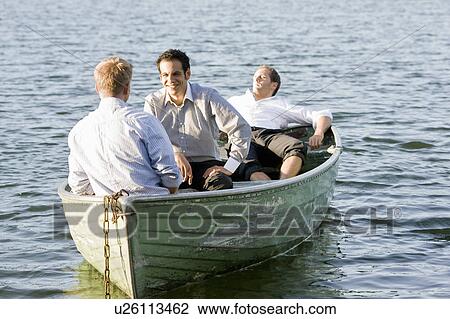 Stock Image - three businessmen relaxing in rowboat. Fotosearch