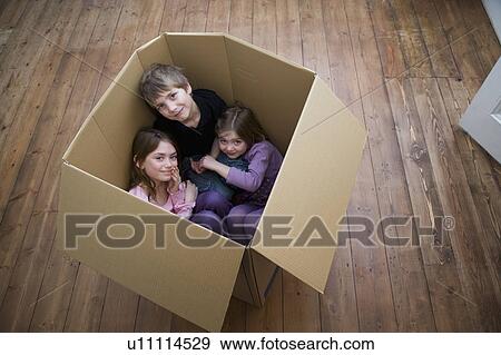 Stock Photo - Three children sitting inside a box.. Fotosearch