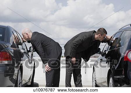 two business men glancing in car View Large Photo Image Stock Photo - two business men glancing in car. Fotosearch