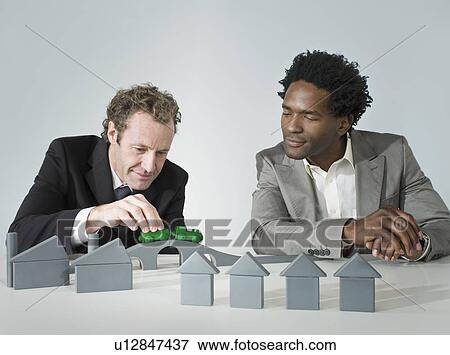 Stock Photo - Two business men play with a train. Fotosearch