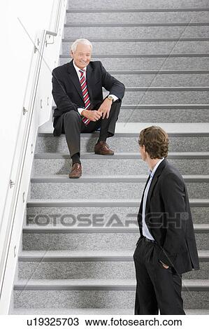 Stock Image - two businessmen on staircase. Fotosearch