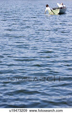 two businessmen relaxing in rowboat View Large Photo Image Stock Photo - two businessmen relaxing in rowboat. Fotosearch