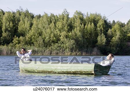 two businessmen relaxing in rowboat View Large Photo Image Stock Photo - two businessmen relaxing in rowboat. Fotosearch