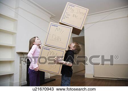 Stock Image - Two children holding a stack of boxes. Fotosearch