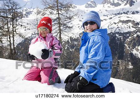 Picture - Two children playing with snow ball.. Fotosearch