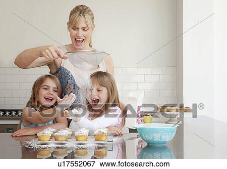 Two girls and a mum baking View Large Photo Image Stock Photo - Two girls and a mum baking. Fotosearch