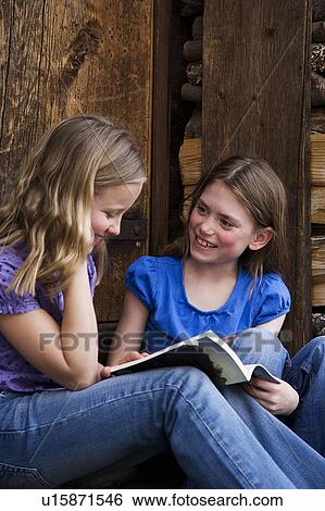 Stock Photograph - Two girls reading.. Fotosearch