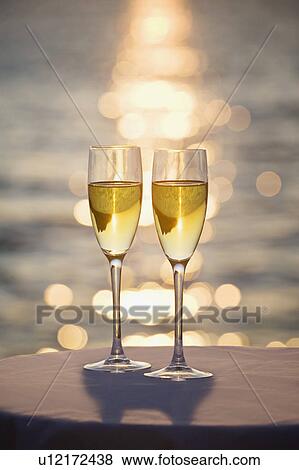 Stock Photo - Two glasses of champagne at sunset. Fotosearch