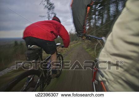 two mountain bikers riding down a track View Large Photo Image Stock Photo - two mountain bikers riding down a track. Fotosearch