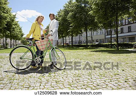 Two people with bicycle in conversation View Large Photo Image Stock Photo - Two people with bicycle in conversation. Fotosearch